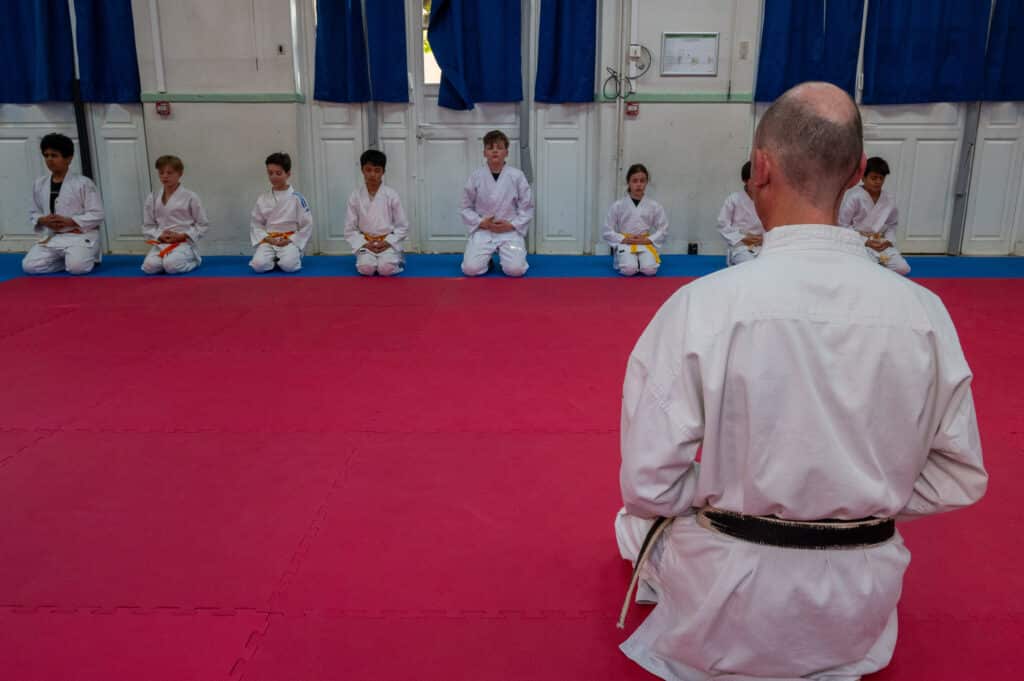 Méditation des jeunes pendant la cérémonie du salut au début du cours de karaté.